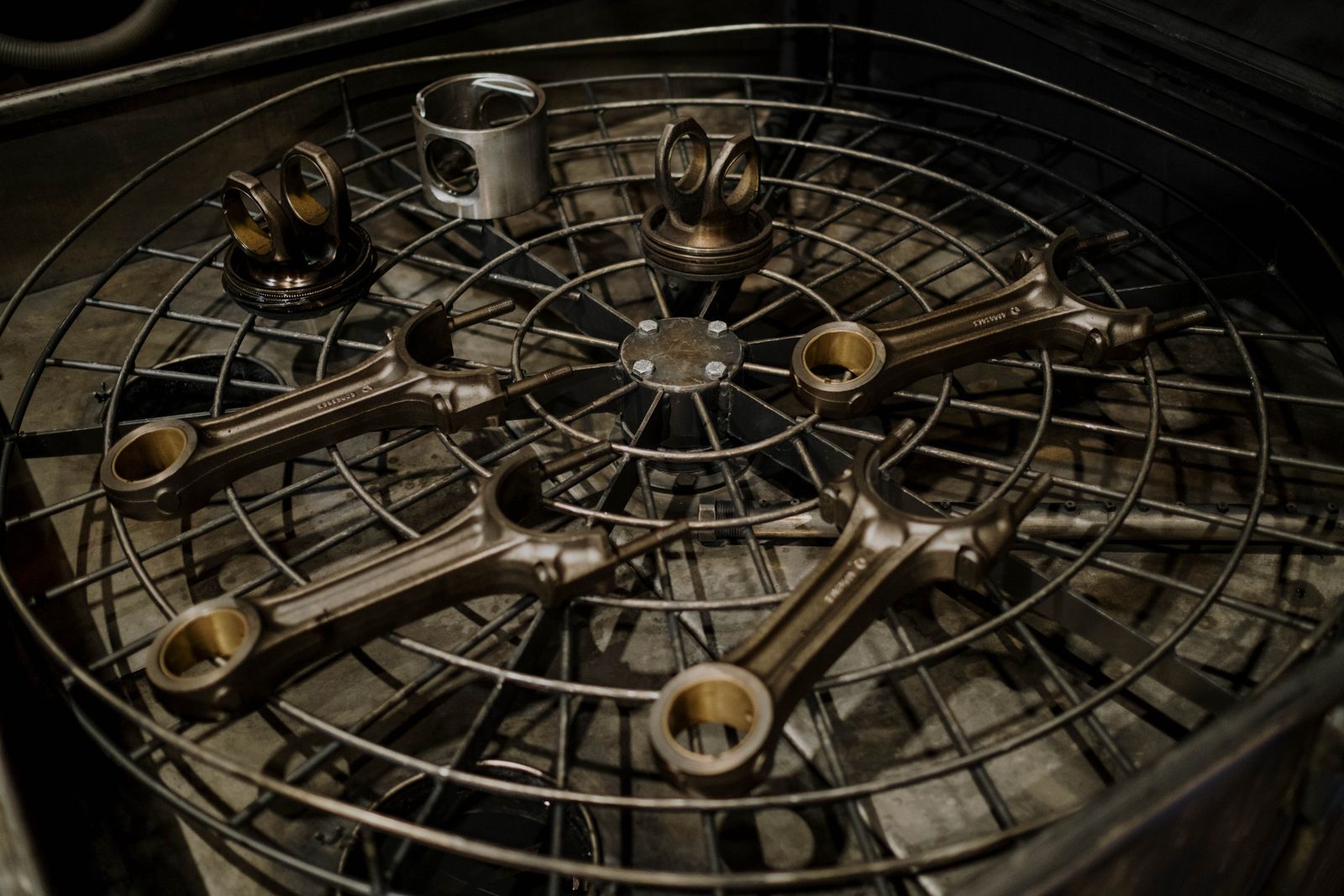 Automotive pistons and connecting rods arranged on an industrial work surface