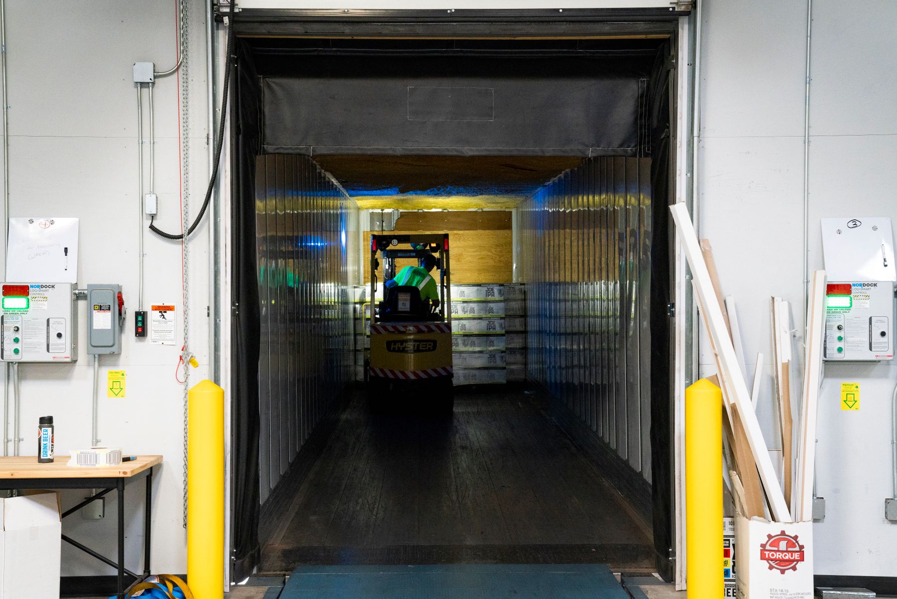 A forklift moving freight at an indoor loading dock
